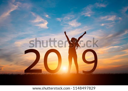 Silhouette of happy woman with New year 2019 concept in sunset background.