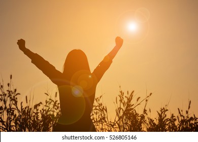 Silhouette Of Happy Women Open Hand In Grass Field At The Sky Sunset