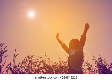 Silhouette Of Happy Women Open Hand In Grass Field At The Sky Sunset