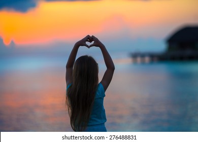 Silhouette Of Heart Made By Kids Hand At Sunset