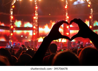 Silhouette of a heart shaped hands and crowd of Audience is power of music concert - Powered by Shutterstock - Get 15% off with code: PIKWIZARD15