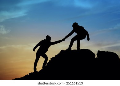 Silhouette Of Helping Hand Between Two Climber
