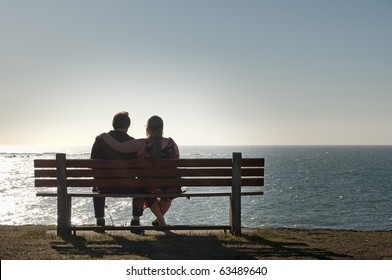 Silhouette of a heterosexual couple enjoying the afternoon on a calm and peaceful relaxing in front of the ocean view. Copyspace above with room for text. - Powered by Shutterstock