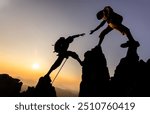 Silhouette of hiker helping each other hike up a mountain at sunset. People helping and, team work concept.