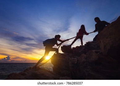 Silhouette Of Hikers Climbing Up On The Mountain,team Work And Helping Concept.