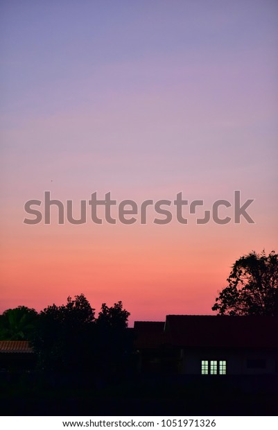 silhouette home and the moon eclipse and\
colorful sky evening in\
thailand.