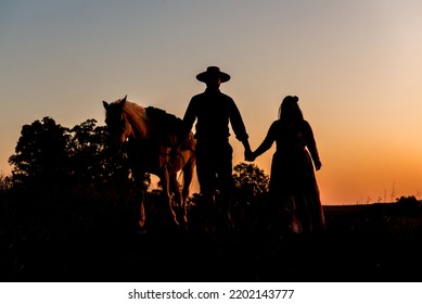 Silhouette Of Horse And Gaucho Family At Sunset In South Brazil