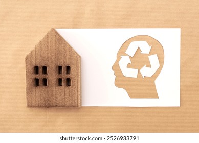 Silhouette of a human head with recycling symbol cut-out next to wooden house on Craft Paper Background, Sustainable and eco friendly Living concept - Powered by Shutterstock