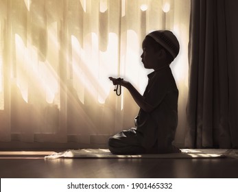 silhouette image of Muslim pre school kid pray to God (Doing  Dua or supplication).Concept of Muslim Kid praying.