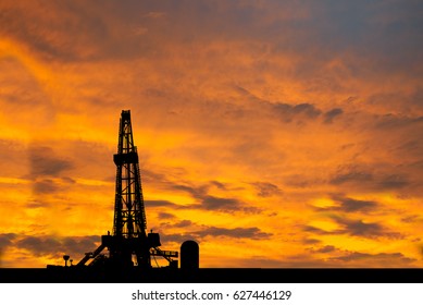 Silhouette image of oil and gas drilling rig in the middle of nowhere with dramatic sky