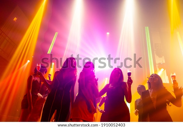 Silhouette\
image of people dance in disco night club to music from DJ on stage\
. New year night party and nightlife concept\
.