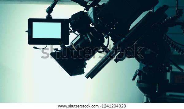 Silhouette images of video camera in tv commercial\
studio production which operating or shooting by cameraman and film\
crew team in set and prop on professional crane and tripod for pan\
tilt or shift