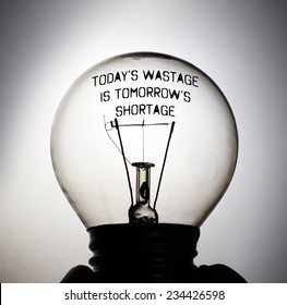 Silhouette Of An Incandescent Light Bulb With The Message Quote: Today's Wastage Is Tomorrow's Shortage.