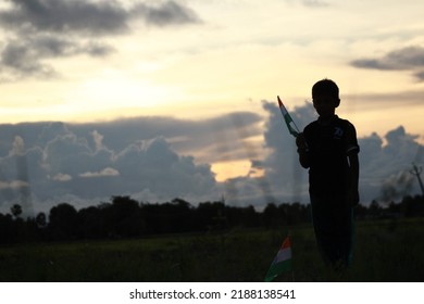 Silhouette Of A Indian Boy Holding The Indian Tricolour Flag Celebrating The Independence Day.