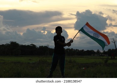 Silhouette Of A Indian Boy Holding The Indian Tricolour Flag Celebrating The Independence Day.