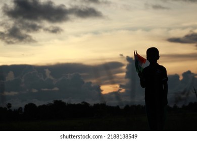 Silhouette Of A Indian Boy Holding The Indian Tricolour Flag Celebrating The Independence Day.