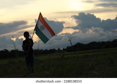 Silhouette Of A Indian Boy Holding The Indian Tricolour Flag Celebrating The Independence Day.