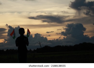 Silhouette Of A Indian Boy Holding The Indian Tricolour Flag Celebrating The Independence Day.