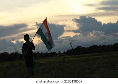 Silhouette Of A Indian Boy Holding The Indian Tricolour Flag Celebrating The Independence Day.