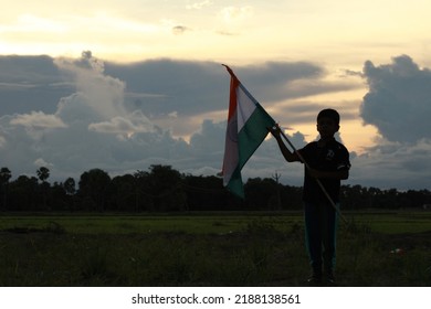 Silhouette Of A Indian Boy Holding The Indian Tricolour Flag Celebrating The Independence Day.