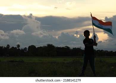 Silhouette Of A Indian Boy Holding The Indian Tricolour Flag Celebrating The Independence Day.