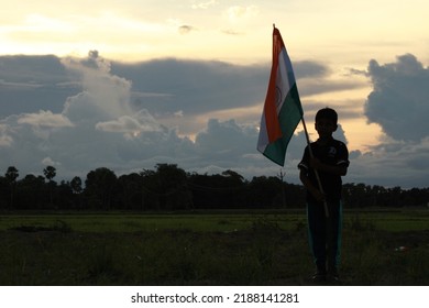 Silhouette Of A Indian Boy Holding The Indian Tricolour Flag Celebrating The Independence Day.