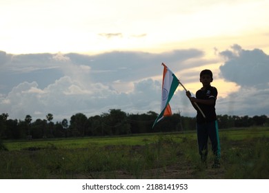 Silhouette Of A Indian Boy Holding The Indian Tricolour Flag Celebrating The Independence Day.