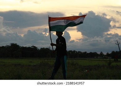 Silhouette Of A Indian Boy Holding The Indian Tricolour Flag Celebrating The Independence Day.