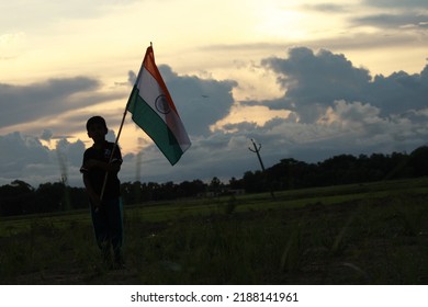 Silhouette Of A Indian Boy Holding The Indian Tricolour Flag Celebrating The Independence Day.