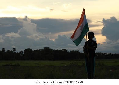 Silhouette Of A Indian Boy Holding The Indian Tricolour Flag Celebrating The Independence Day.