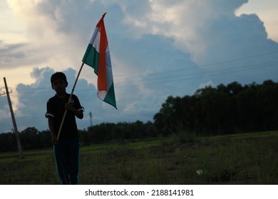 Silhouette Of A Indian Boy Holding The Indian Tricolour Flag Celebrating The Independence Day.