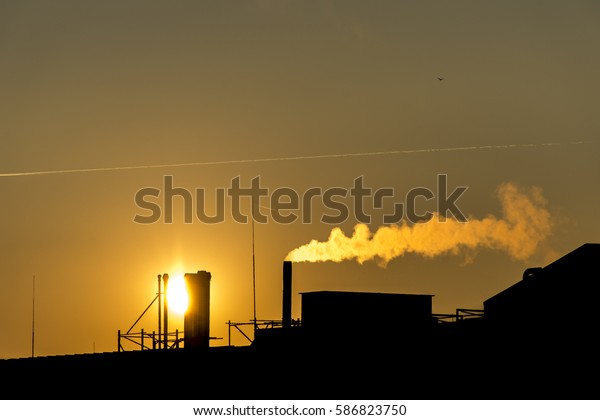 Silhouette, Industrial factory smoke from\
smokestacks over colorful sunset sky\
industry