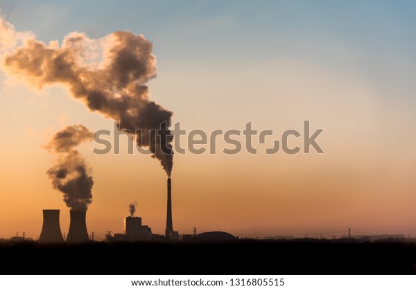 silhouette of industrial factory\
smoke stack of coal power plant from chimney up on sky cause air\
pollution and destroy the Earth\'s atmosphere, Global warming\
concept