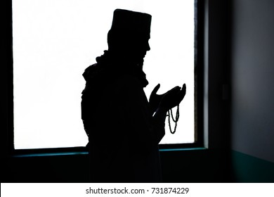 Silhouette of Islam muslim man in custom dress praying in mosque