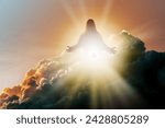 Silhouette of Jesus Christ in Heaven, up in the clouds against a bright ethereal light. Christian concept of salvation.