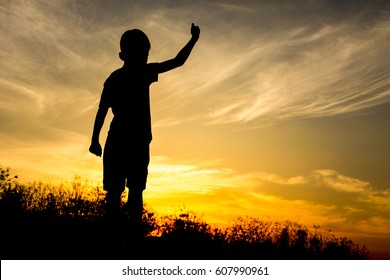 Silhouette of kid and the beautiful sky in the evening