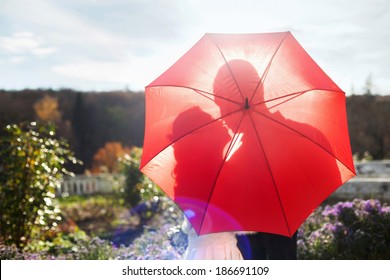 Silhouette of kissing couple under umbrella - Powered by Shutterstock