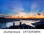 Silhouette of Kowloon, Hong Kong Island and Victoria Harbour under v-shaped anti-crepuscular ray during sunset. Photo taken from Devil
