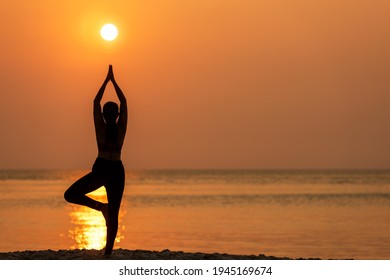 Silhouette Lifestyle Frau Yoga Sport gesundes Leben.  Junge Mädchen oder Menschen stellen Körper Gleichgewicht lebenswichtig Zen-und Meditation-Training und Fitness-Sport Outdoor-Sonnenuntergang in der Nähe des Strandes. Meereshintergrund.