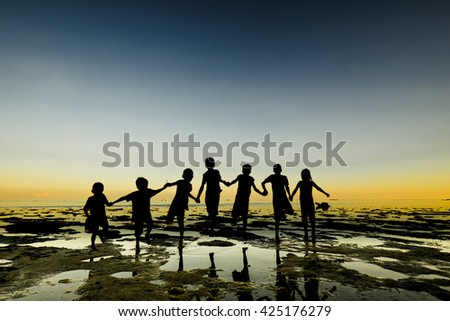 Silhouette of lineup group of kid, people stand on beach with water reflection