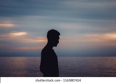 Silhouette of a lonely man standing at the sea with twilight sky background.Copy space on above. Concept for show Lonely moment, need somebody to talk about everything.Or waiting for a pointless.
 - Powered by Shutterstock