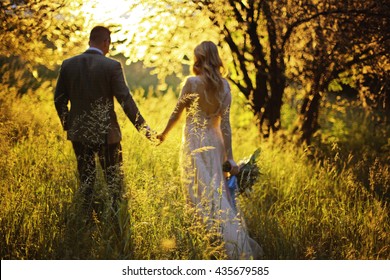 Silhouette of a loving couple on the background of the setting sun, hills, meadow and trees. Just married. Walk at sunset through the mountains at sunset.Romantic Married young family