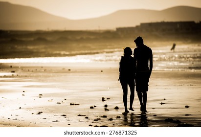 Silhouette Of The Loving Couple, Walking On The Beach