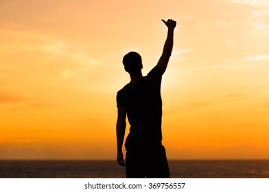 Silhouette of male celebrating with arm up towards the sunrise. Achievement concept.  - Powered by Shutterstock