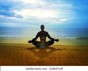 Silhouette Of A Male Figure Meditating On The Beach