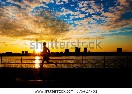 Silhouette of male runner at sunset along Hudson River on west side of Manhattan