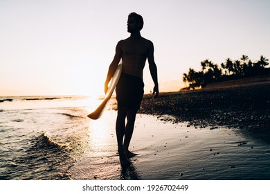 Silhouette Of Male Spending Evening For Surfing During Summer Twilight At Carribean Sea, Amateur Man With Professional Surfboard Recreating With Sportive Activity In Thailand Visiting Phuket Beach