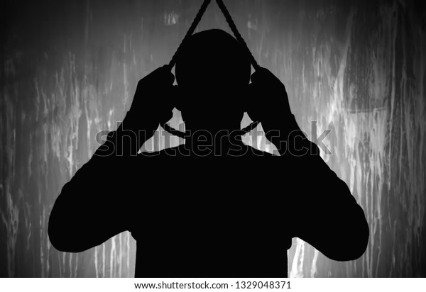 Silhouette of male suicider going to hang\
himself against grunge\
background