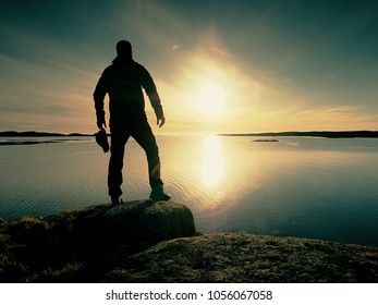 Silhouette of man. Beautiful sunset touch the sea at the horizon, clear blue sky. Hiker enjoy natural scenery