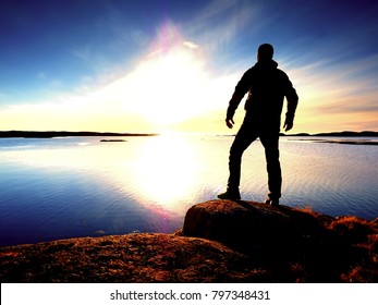 Silhouette of man. Beautiful sunset touch the sea at the horizon, clear blue sky. Hiker enjoy natural scenery